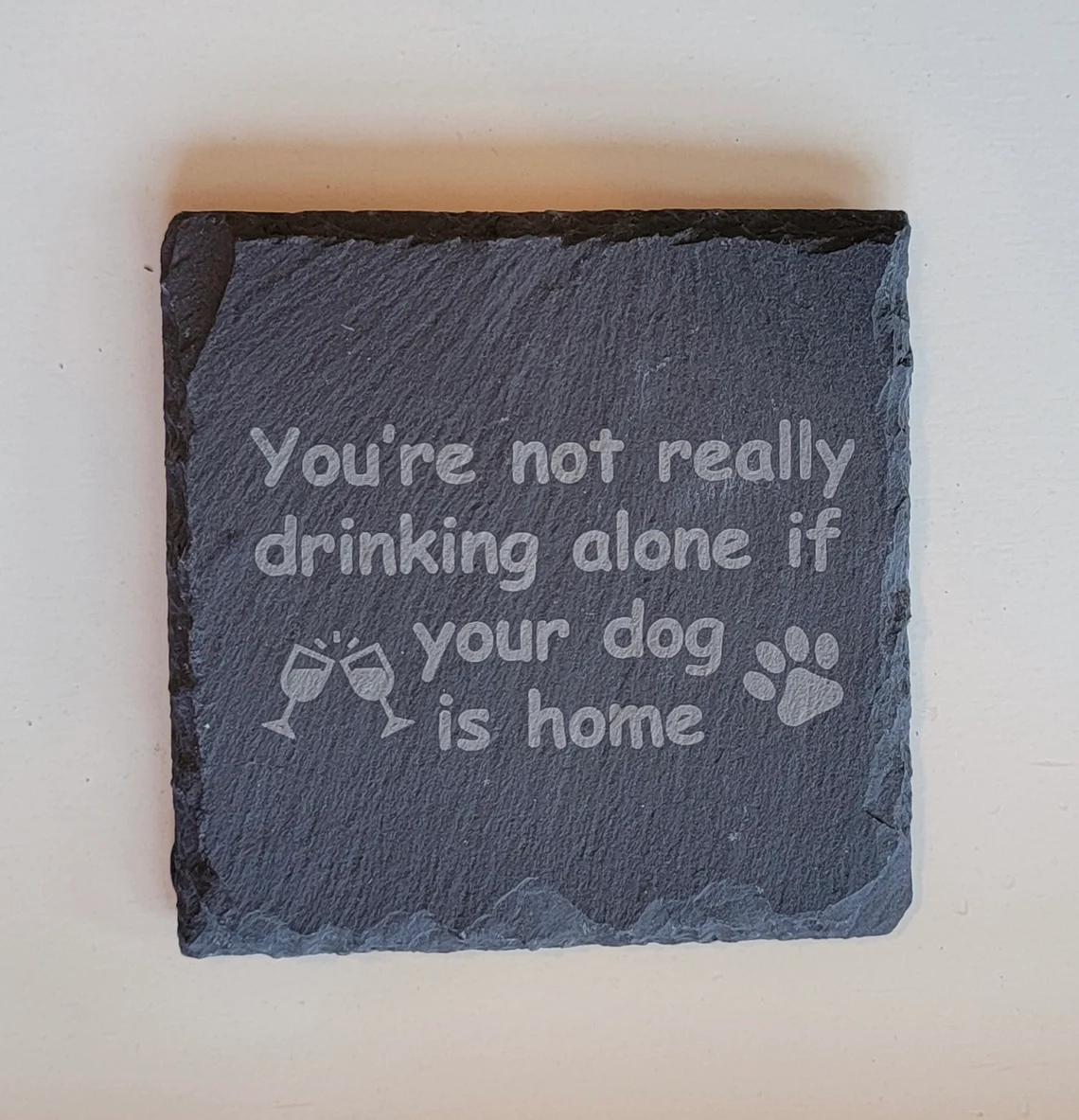 coaster saying "it's not drinking alone if the dog is home"