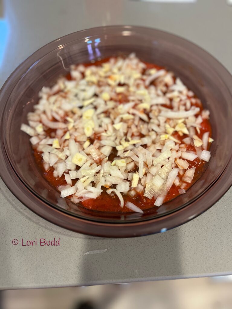 tomato paste with diced onion and garlic in dish