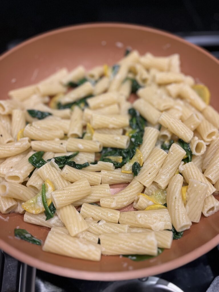 pasta with wilted spinach and squash in pan